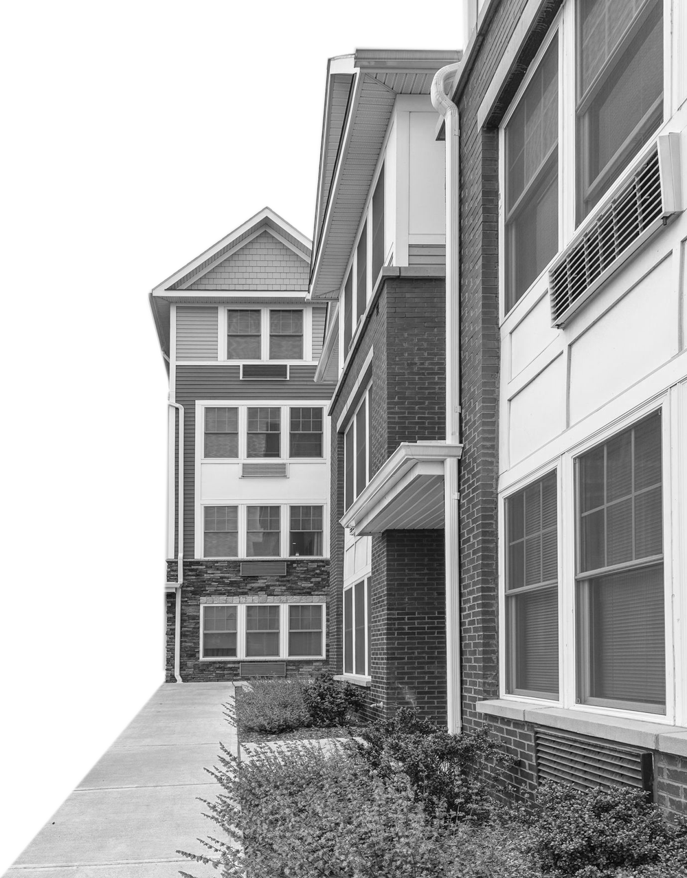 Brick and siding multifamily apartment buildings along a landscaped walkway