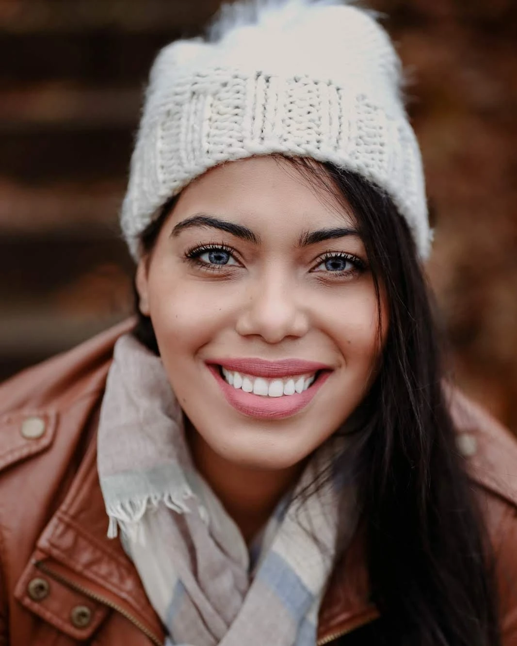 Portrait of Gabriela Espinal smiling, in a knit hat and leather jacket
